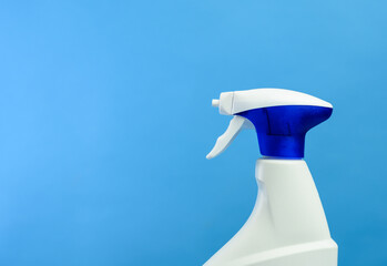 white plastic bottle with spray and foam nozzle with detergent on blue background