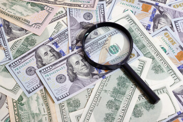 Magnifying glass on the background of bundle dollars - texture, background