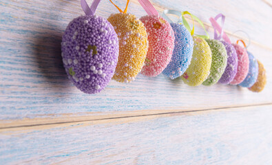 Decorative Easter eggs over blue wooden background. Easter holiday greeting. Selective focus