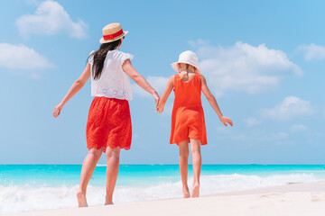 Beautiful mother and daughter at Caribbean beach enjoying summer vacation.