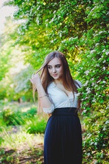 young attractive woman in long dress in spring garden with bouquet of purple lilacs. Sunset light. Spring background. International Woman's Day. Natural beauty. 