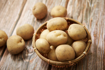 Fresh raw potatoes on a wooden background