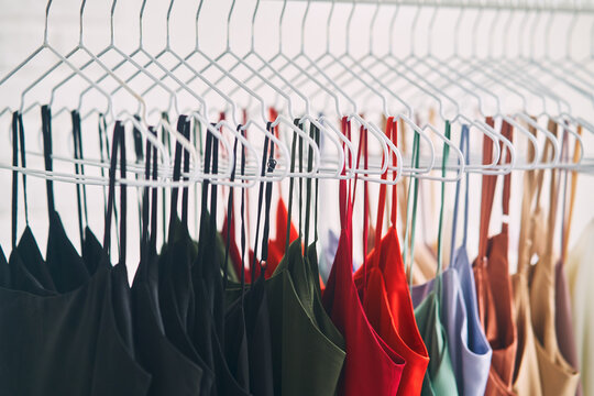 Multi-colored dresses hang on hangers in the store. Sale of women's dresses
