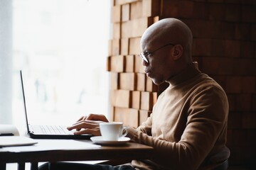 African american business man with laptop in a cafe