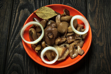 Suillus luteus or Boletus luteus mushrooms marinated in a plate with spices and onions on a vintage table. Top view