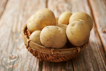 Fototapeta na wymiar Fresh raw potatoes on a wooden background