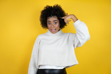 African american woman wearing casual sweater over yellow background smiling and thinking with her fingers on her head that she has an idea.