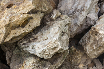 Brick Stone shabby rocks and separated by large cracks and layers. Rough, rough gray stone or rocky mountain texture