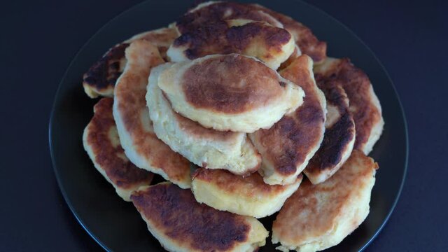 Potato cakes, ukrainian name potato zrazy, stuffed mushrooms or meat or cheese with herbs cream are fried in vegetable oil on black background, close up, rotates. Traditional Ukrainian cuisine