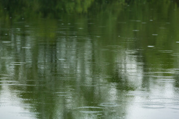 Fototapeta na wymiar Regentropfen auf einem See als Wettervorhersage