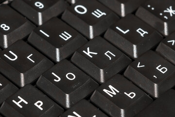Perspective of the keyboard of a laptop in black and white blur. keyboard close up with black keys
