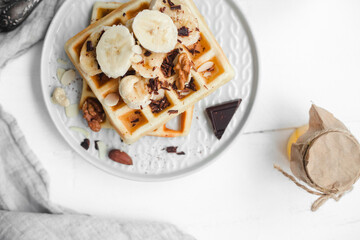 Sweet Belgian waffles with banana and chocolate and nuts