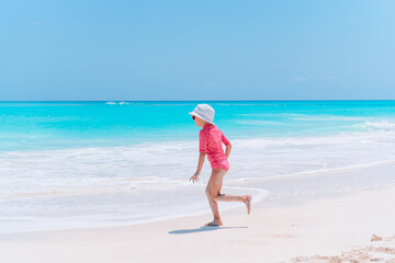 Adorable little girl have fun at tropical beach during vacation