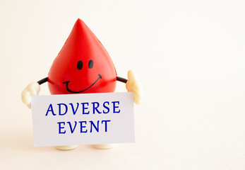 A toy drop of blood holds a white paper card with the inscription ADVERSE EVENT.