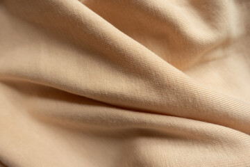 Folded simple beige cotton jersey fabric from above