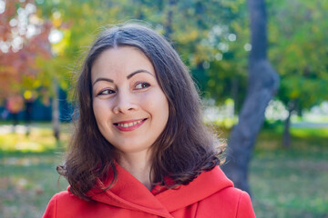 Beautiful young smiling woman in red coat