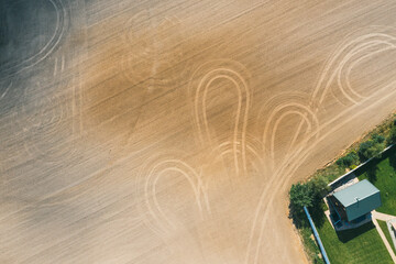 Picture of an aerial view with a drone of a field and field with tractor tracks