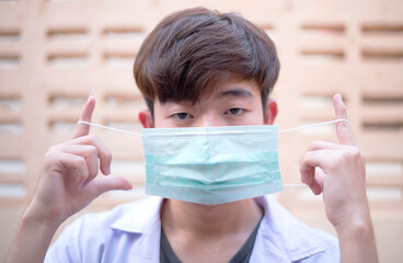 A young man sick , wearing a mask on the face for protection Prevent infection and viruses (COVID-19)