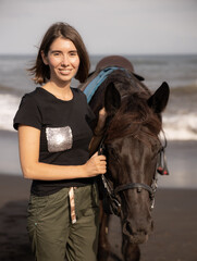 Obraz premium Portrait of happy woman and brown horse. Young Caucasian woman hugging horse. Romantic concept. Love to animals. Nature concept. Bali