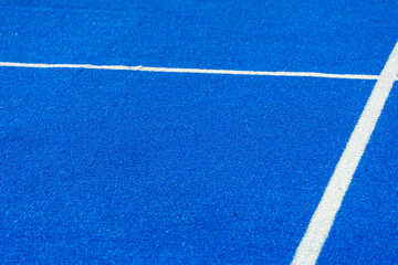 Fototapeta na wymiar Bright blue tennis, paddle ball or pickleball court close up of service line outdoors.