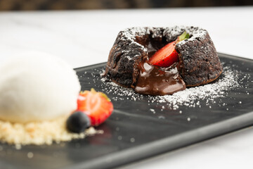 Chocolate fondant with vanilla ice-cream and berries. Hot chocolate pudding with melted chocolate...