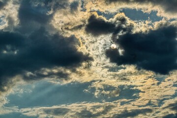 Fototapeta Słońce przebijające się przez chmury, dramatyczne niebo, niepewna aura pogody, wiatry rozganiające chmury obraz