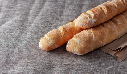 French baguettes on a table covered with cloth. Selective focus.
