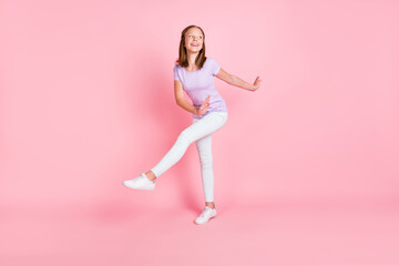Fototapeta na wymiar Full size photo of funky positive happy little girl look empty space dance isolated on pink color background