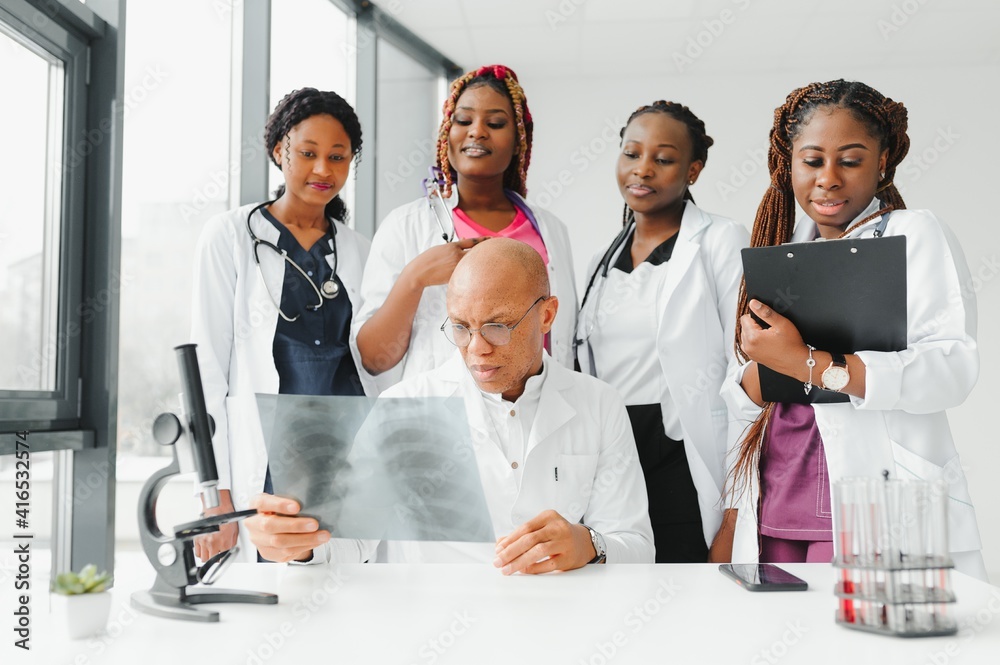 Wall mural confident african medical doctor and colleagues portrait in hospital