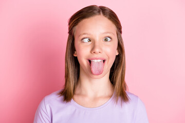 Photo of funny childish teenage girl make funky face stick tongue out isolated on pastel pink color background © deagreez