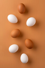 Brown  and white chicken egges on beige background. Chicken eggs on the table. Fresh eggs on breakfast.