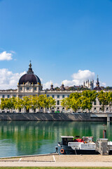 Grand Hôtel-Dieu and Fourvière hill in Lyon, France with a barge in the foreground seen from the Rhône river