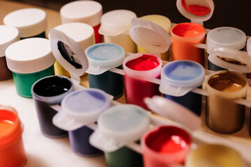 Jars of gouache paint. Creativity, education, art, drawing, painting concept, background. Selective focus.
