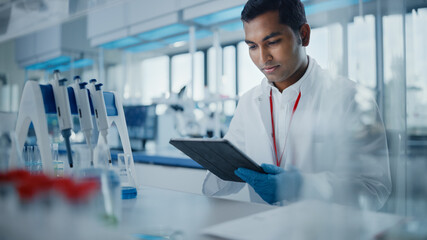 Medical Research Laboratory: Portrait of a Handsome Male Scientist Using Digital Tablet Computer to Analyse Data. Advanced Scientific Lab for Medicine, Biotechnology, Microbiology Development
