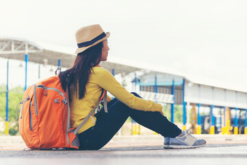 Asia young women traveler and tourist traveling backpack holding map and waiting in a train station platform. Travel Concept.