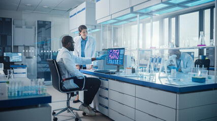 Modern Medical Research Laboratory: Two Scientists Use Computer with Screen Showing DNA Gene...