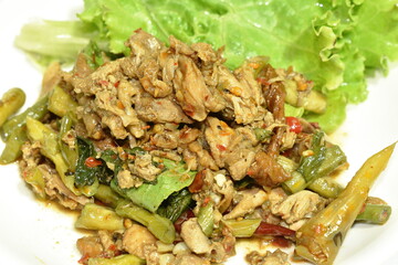 spicy fried chop duck meat with yard long bean and basil leaf on plate