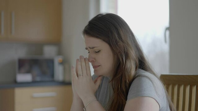 Close-up of a Thrilled woman with closed eyes praying to God for a miracle