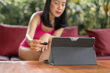 Woman in swimming suit hand plugging a flash drive on a laptop.