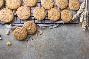 Oatmeal cookies with cereals, seeds and nuts, concrete background. Healthy vegan cookies. Top view.
