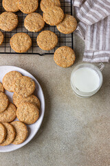 Healthy oatmeal cookies with cereals, seeds and nuts with a cup of milk on concrete background. Diet vegan cookies. Top view.