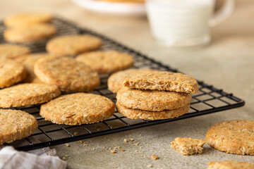 Healthy oatmeal cookies with cereals, seeds and nuts with a cup of milk on concrete background. Diet vegan cookies.