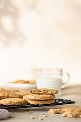 Healthy oatmeal cookies with cereals, seeds and nuts with a cup of milk on concrete background. Diet vegan cookies.