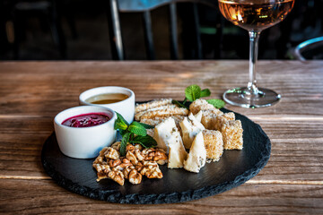 cheese slicing with nuts, sauces and wine