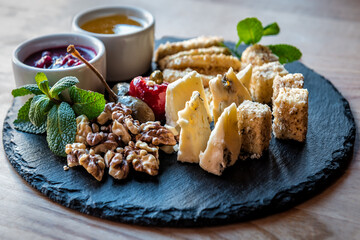 different cheese slicing with nuts and sauces