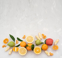 Many different fruits: tangerines, oranges, grapefruits, apples and pears on pale gray background. Fruits contain many vitamins, prepare fresh juices useful for healthy lifestyle. Close-up, horizontal