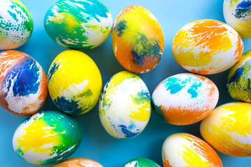 Top view of multicolored Easter eggs on a blue background. Happy Easter card. Dyed Easter eggs. Copy space for your text. Flat lay style. Top view. 
