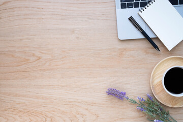 Top view above of Wooden office desk table with keyboard of laptop,  coffee cup and notebook with equipment office supplies. Business and finance concept. Workplace, Flat lay with blank copy space.