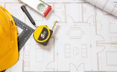 Construction concept. Residential building drawings and hardhat on an office desk