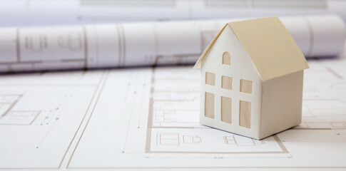 Construction concept. Residential building drawings and architectural house model on an office desk